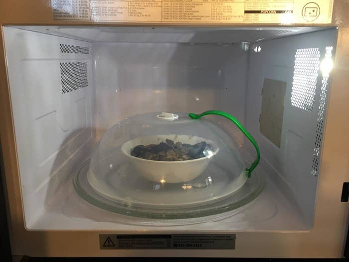 reviewer image of the microwave splatter cover over a bowl of food in a microwave