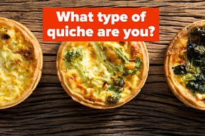 Three quiche pies are spread out on a wooden table labeled, "Which type of quiche are you?"