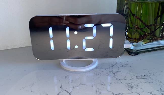 a reviewer photo of a digital alarm clock 