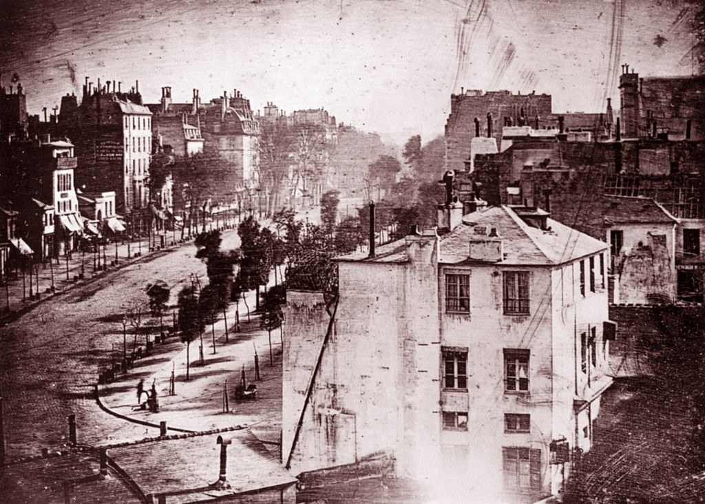 Old photo of a tree-lined Paris street