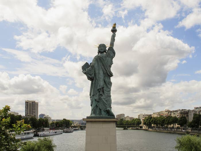 Statue Of Liberty Replica Against Cloudy Sky 