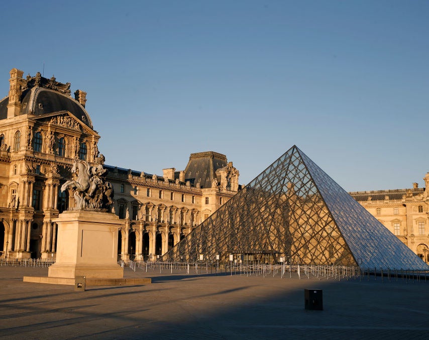 The beautiful, old Louvre Museum building and a glass pyramid in the courtyard