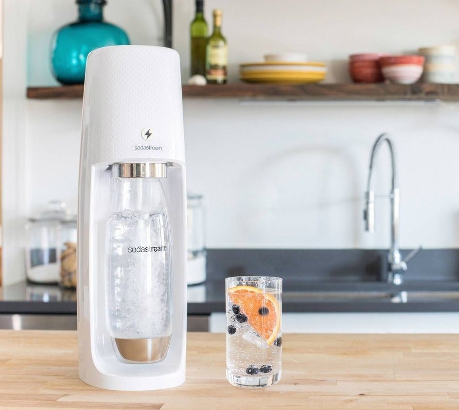 The SodaStream on a kitchen countertop shown with a carbonate beverage