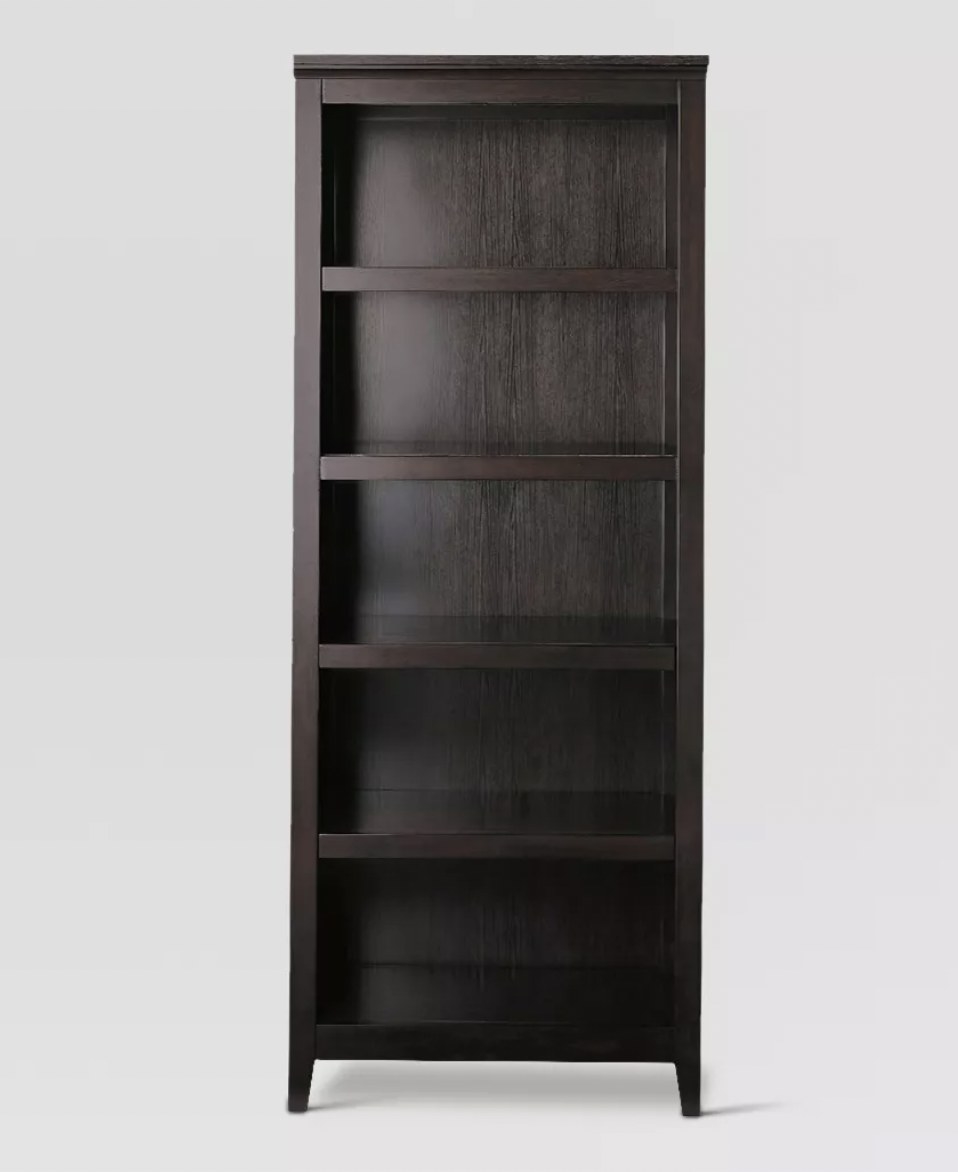 a tall brown bookshelf with five shelves