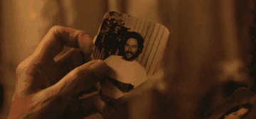 A GIF of Fern holding an old photo of her husband when he was young