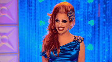 GIF of Bianca in a blue satin gown smiling on the Drag Race stage