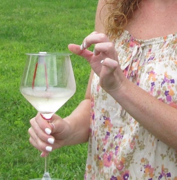 A model with the lid on their wine glass 