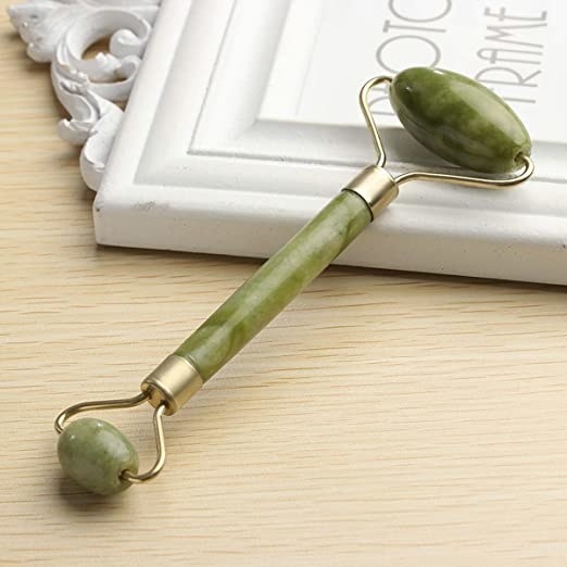Green jade roller with gold accents.