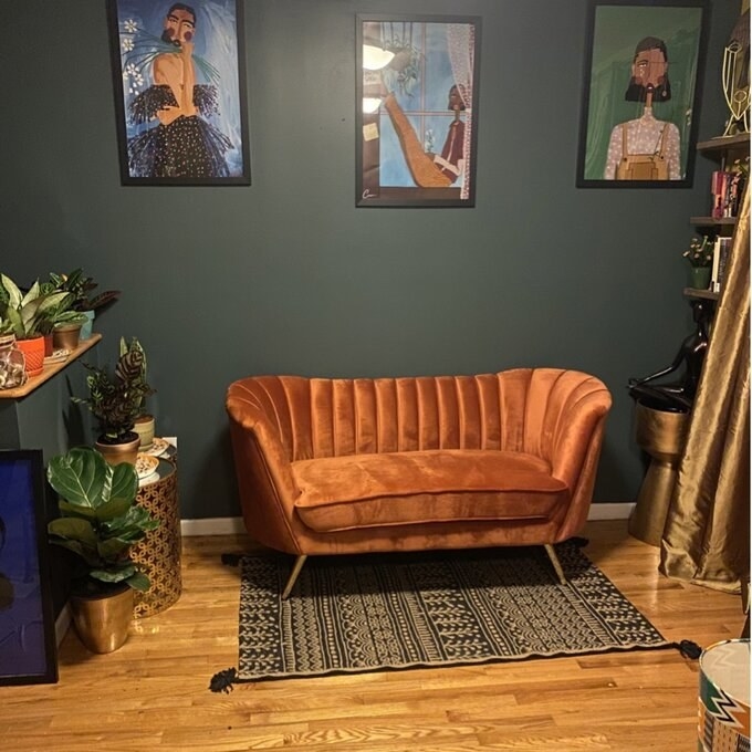 Reviewer's picture of the loveseat, which has a back that wraps around the sides and slightly into the front, in almost a "C" shape
