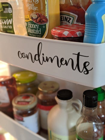 Image of a fridge shelf with a black cursive sticker label that says 