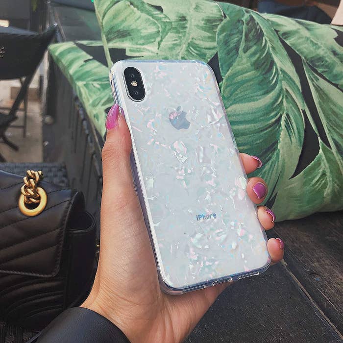 A person holding up an opalescent phone case