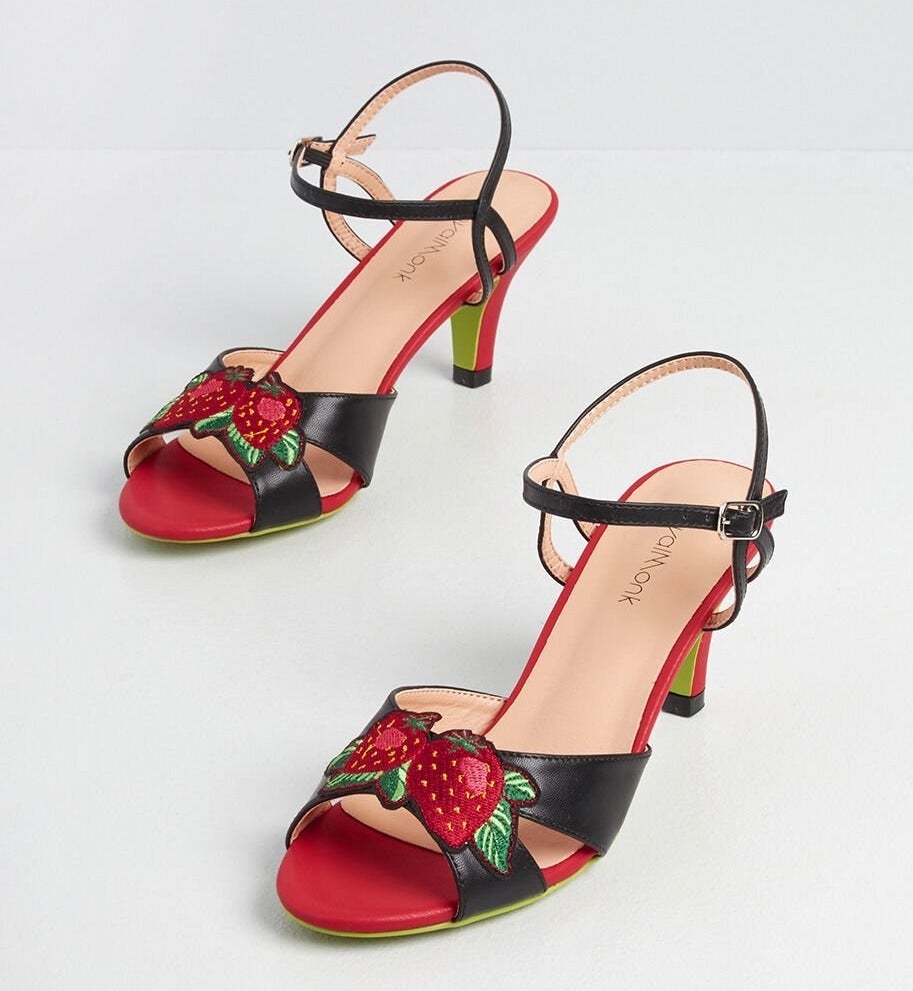 red and black kitten heels with ankle straps and strawberries across the toes