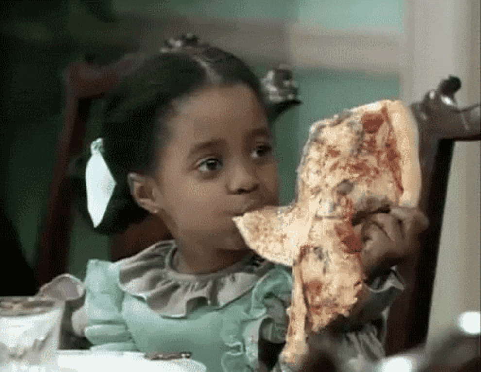 Child from The Cosby Show eating a massive piece of pizza 