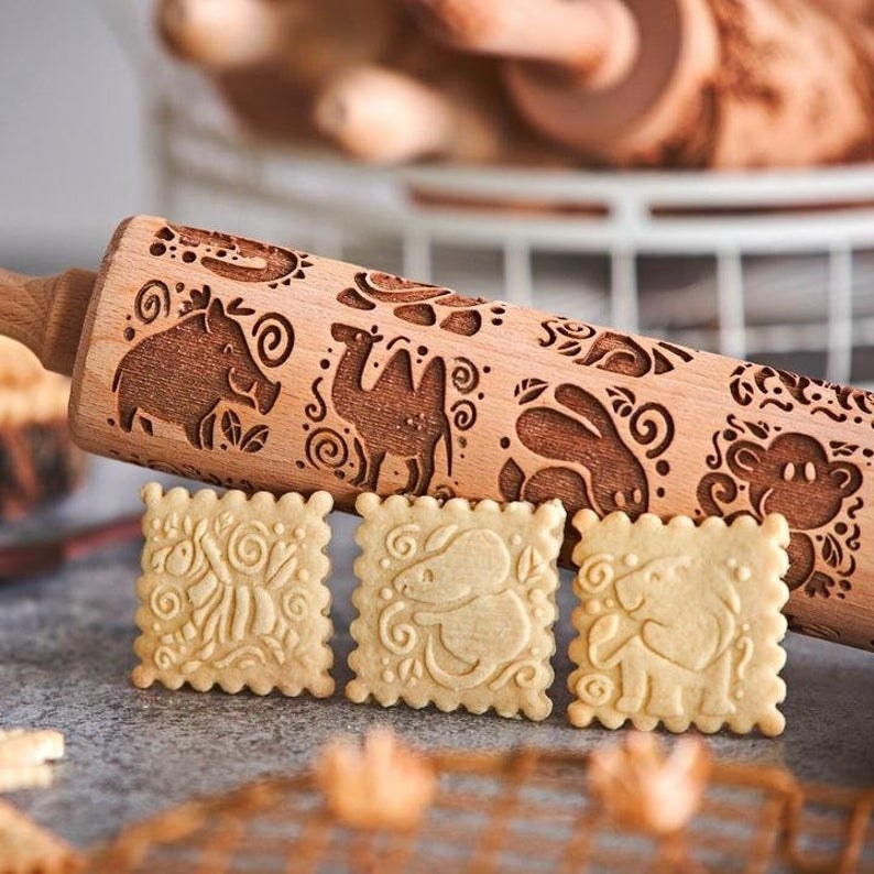 cookies with cute animals on it and an embossed rolling pin