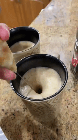 Reviewer using the frother to frother milk in a cup 