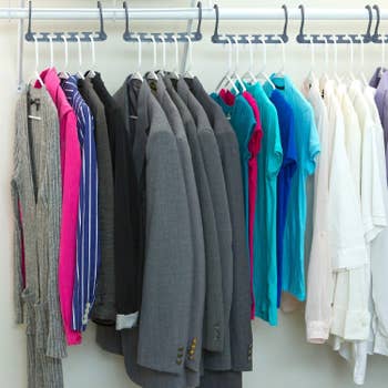 Product in use in closet with them fully extended on the closet rod, each holding several clothing items
