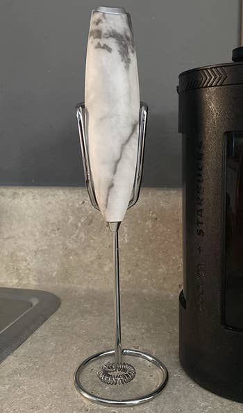 Reviewer's white marble handheld frother on its stand
