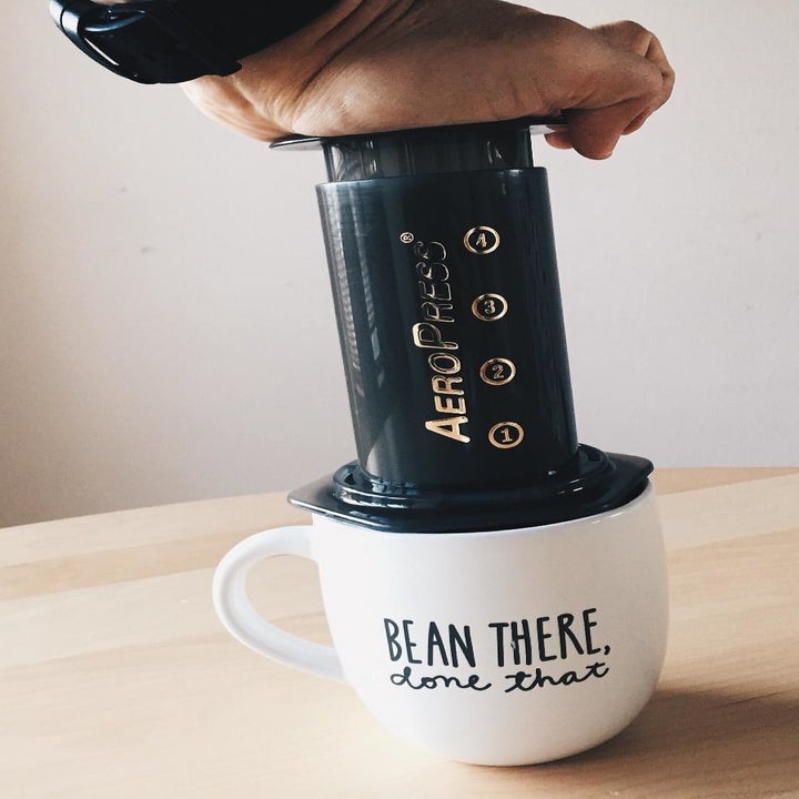a reviewer using the Aeropress over a mug