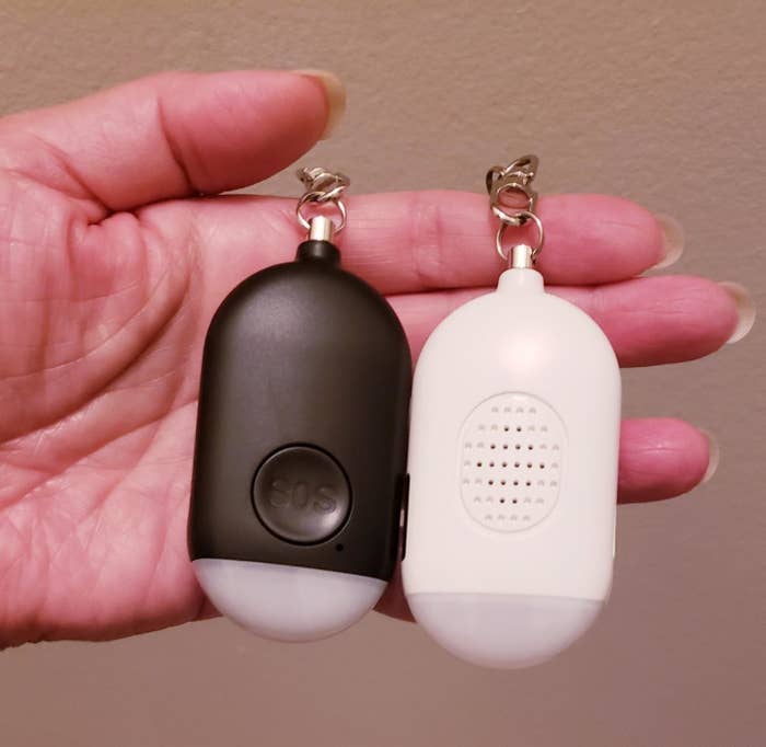 Reviewer holding SOS keychain alarm