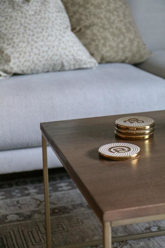 gold and white coasters with @ symbol on wooden table