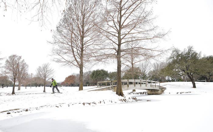 A person snow walks over a bridge