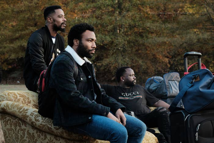 Lakeith Stanfield, Donald Glover, and Brian Tyree Henry sit on a couch in the TV show Atlanta