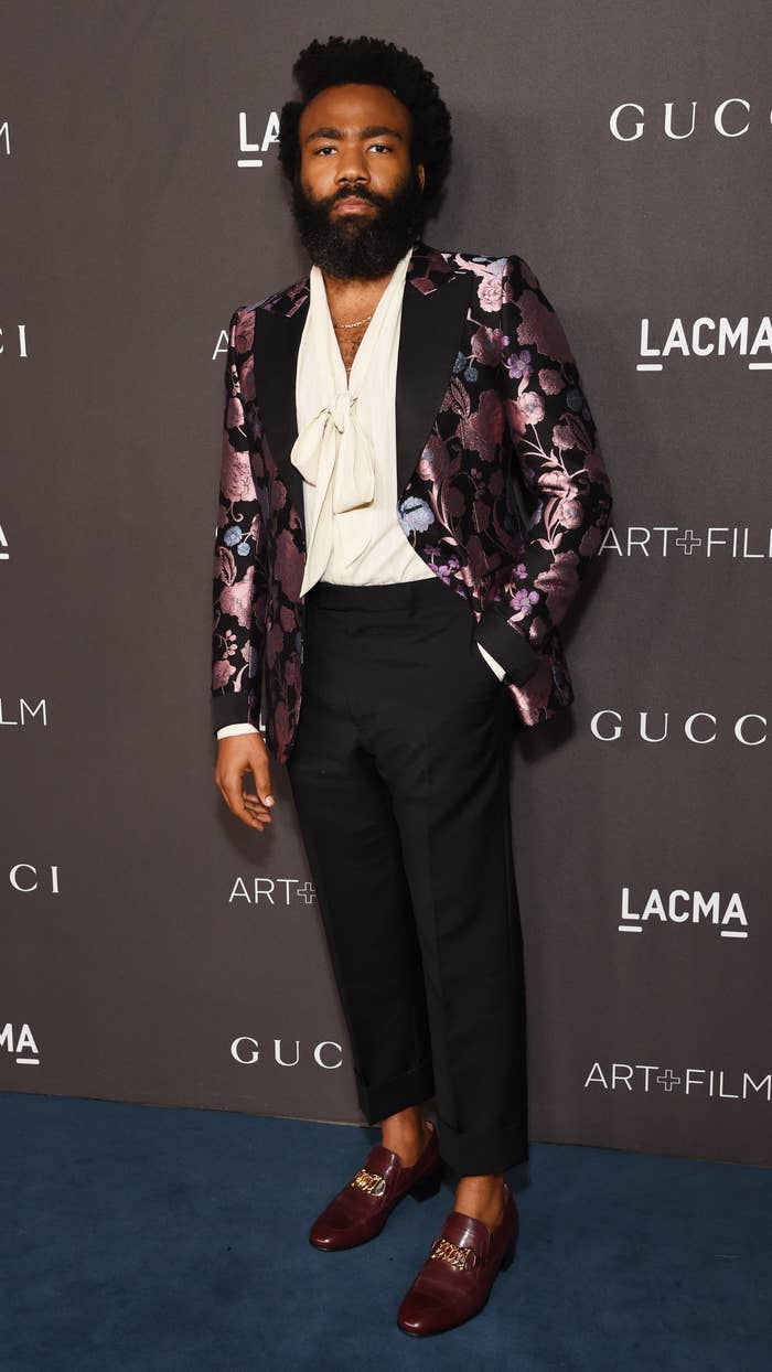 Donald Glover at a gala in Los Angeles in November 2019 wearing a floral patterned blazer and a flow-y blouse