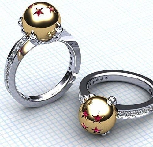 A pair of matching rings with a diamond-encrusted band and a gold ball encrusted with ruby stars 