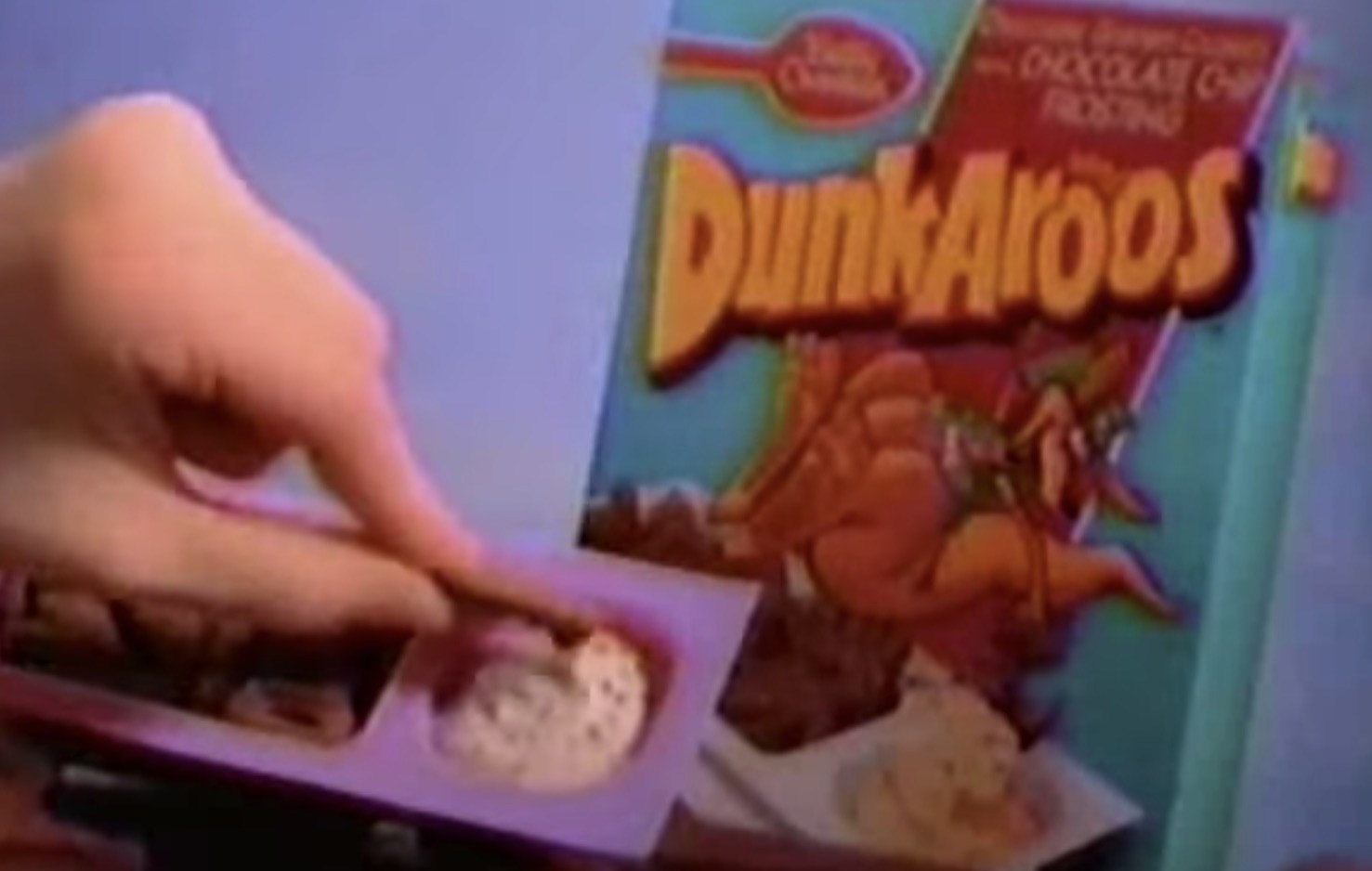A screenshot of a kid's dipping into a cookie into the Dunkaroos cream