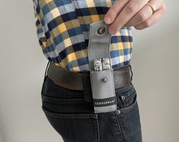 Reviewer showing Leatherman sheath opened and attached to belt
