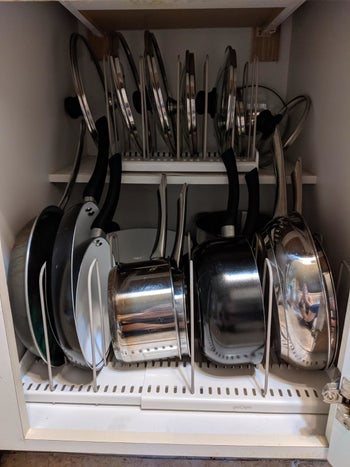 reviewer's cluttered pots and pans cabinet before using the expandable rack 
