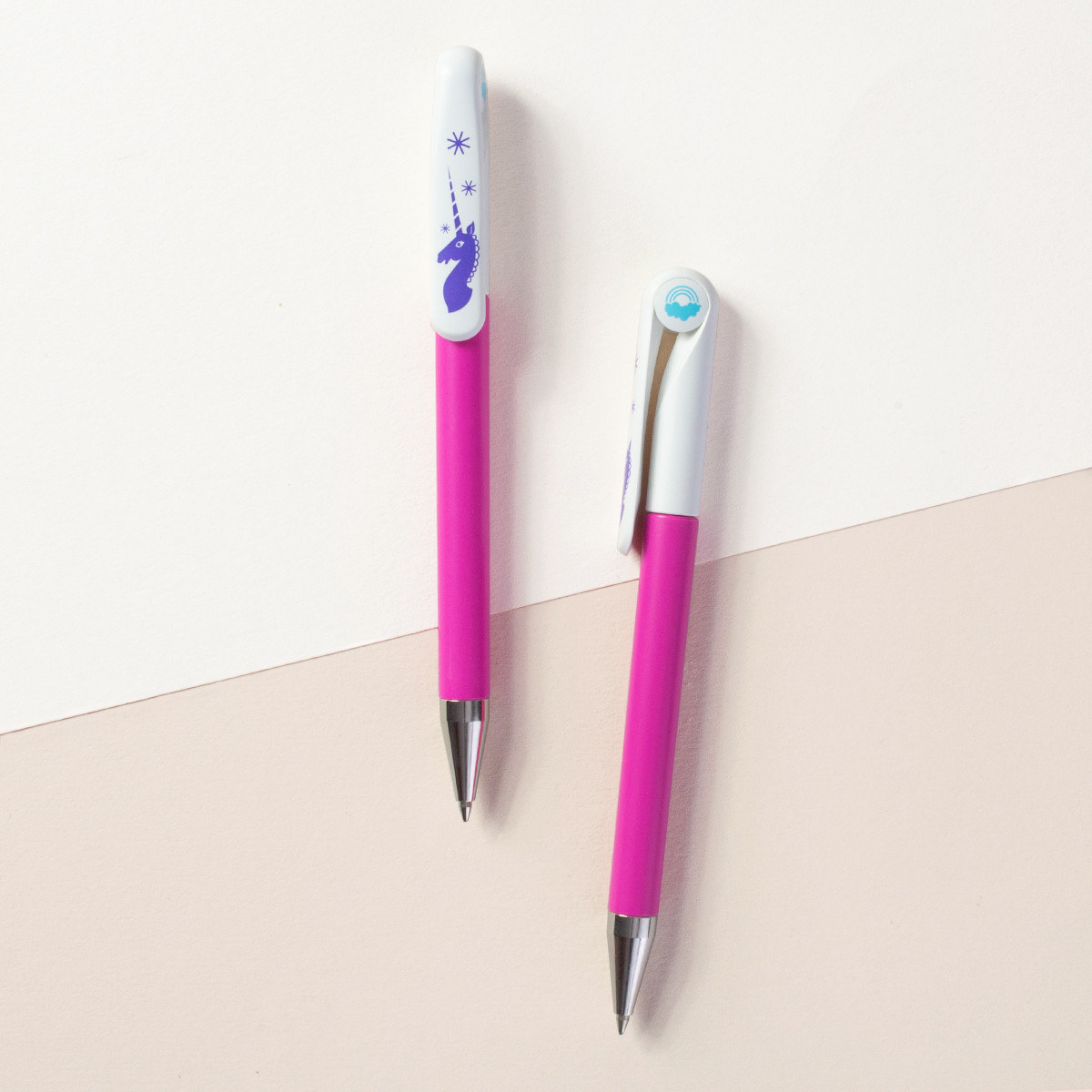 pink ballpoint pen with unicorn and rainbow illustrations at the top