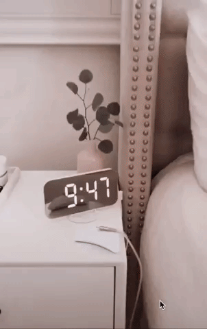 a gif of a hand turning the alarm clock to show the three USB ports on the side 