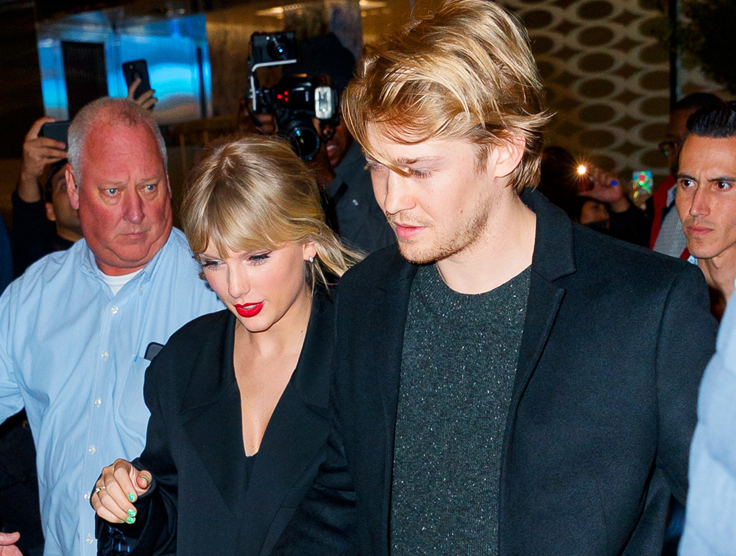 Taylor and Joe walk to their car in a paparazzi photo