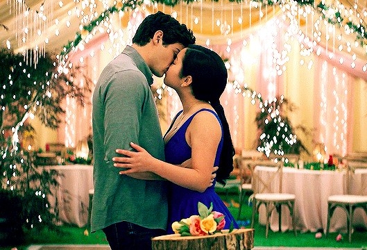 Peter and Lara Jean kissing in a marquee set up for a wedding