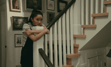 Lara Jean leaning on the banister.