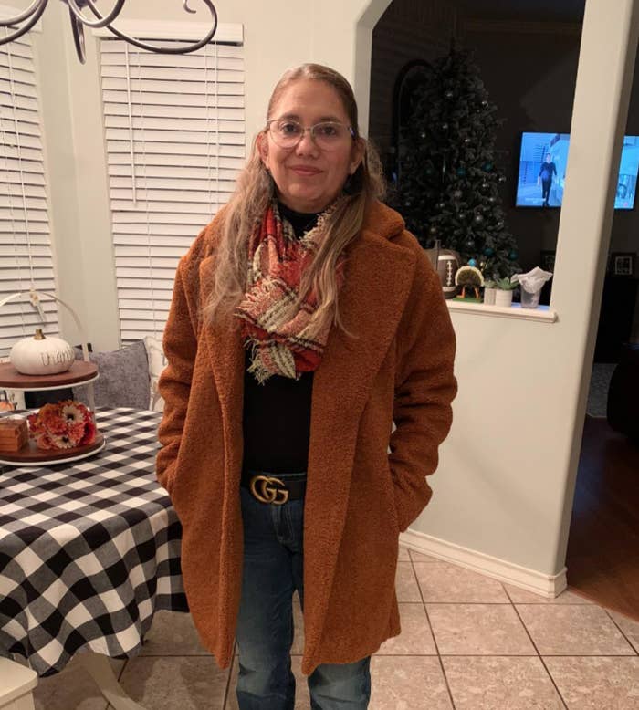 A reviewer wearing the coat in brown with a scarf