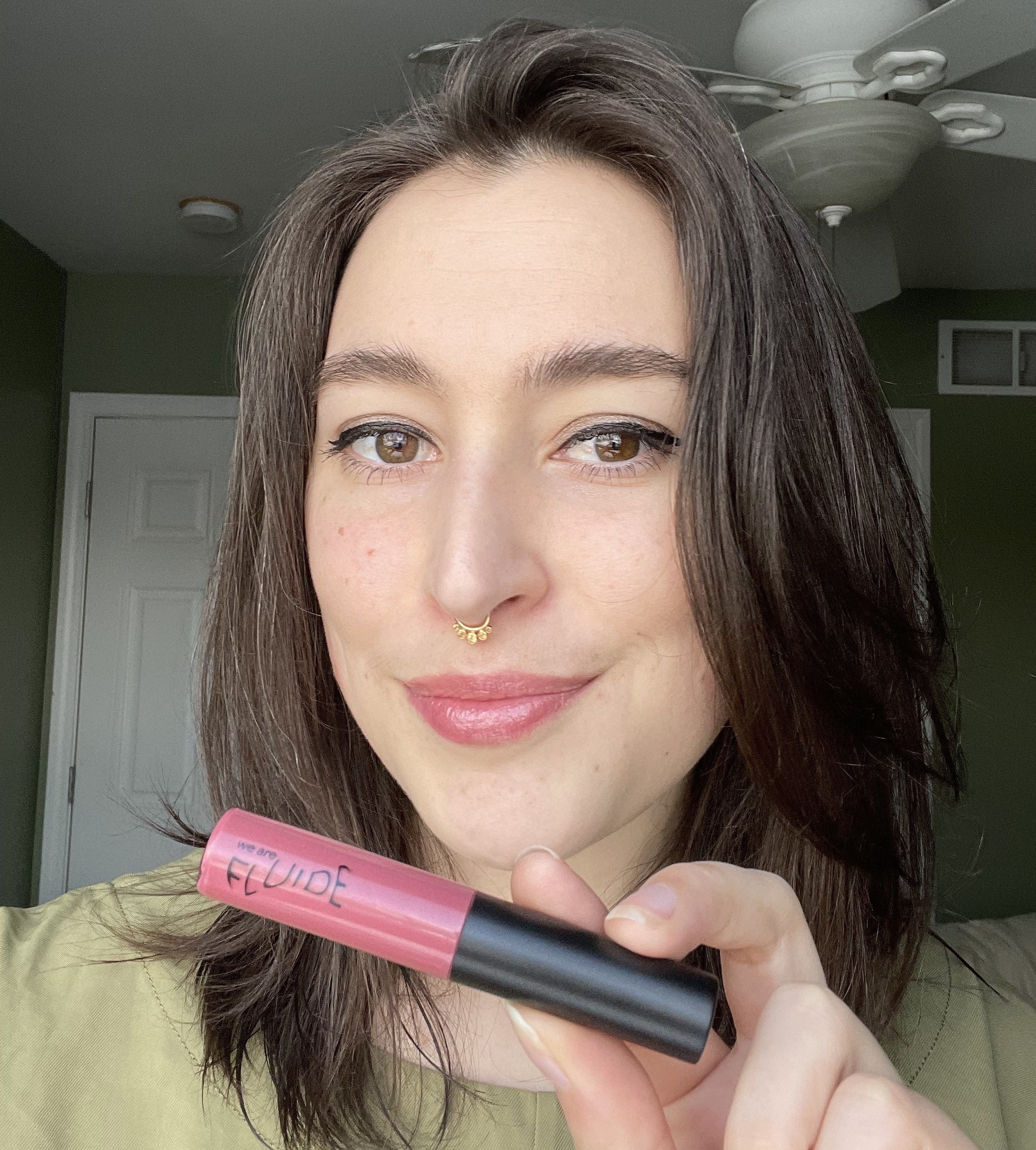 buzzfeed editor holding and wearing the light pink gloss 