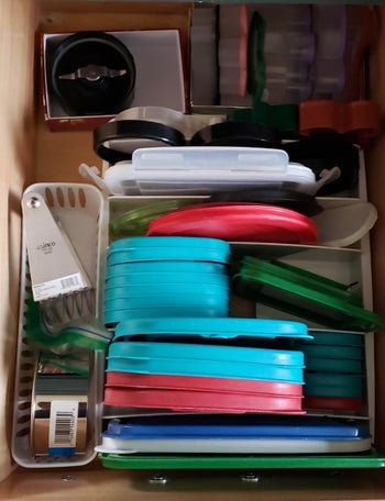 the same drawer with the lids neatly stored int he organizer