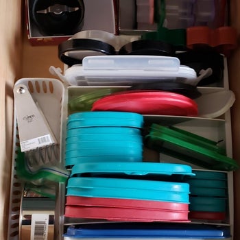 the same drawer with the lids neatly stored int he organizer