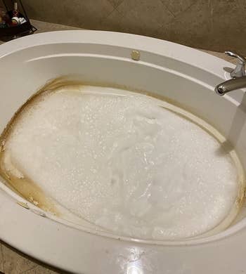 a reviewer's dirty jetted tub being cleaned with water and the cleaner