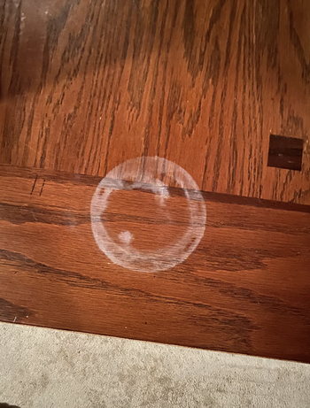 a white watermark ringlet on a reviewer's wooden table
