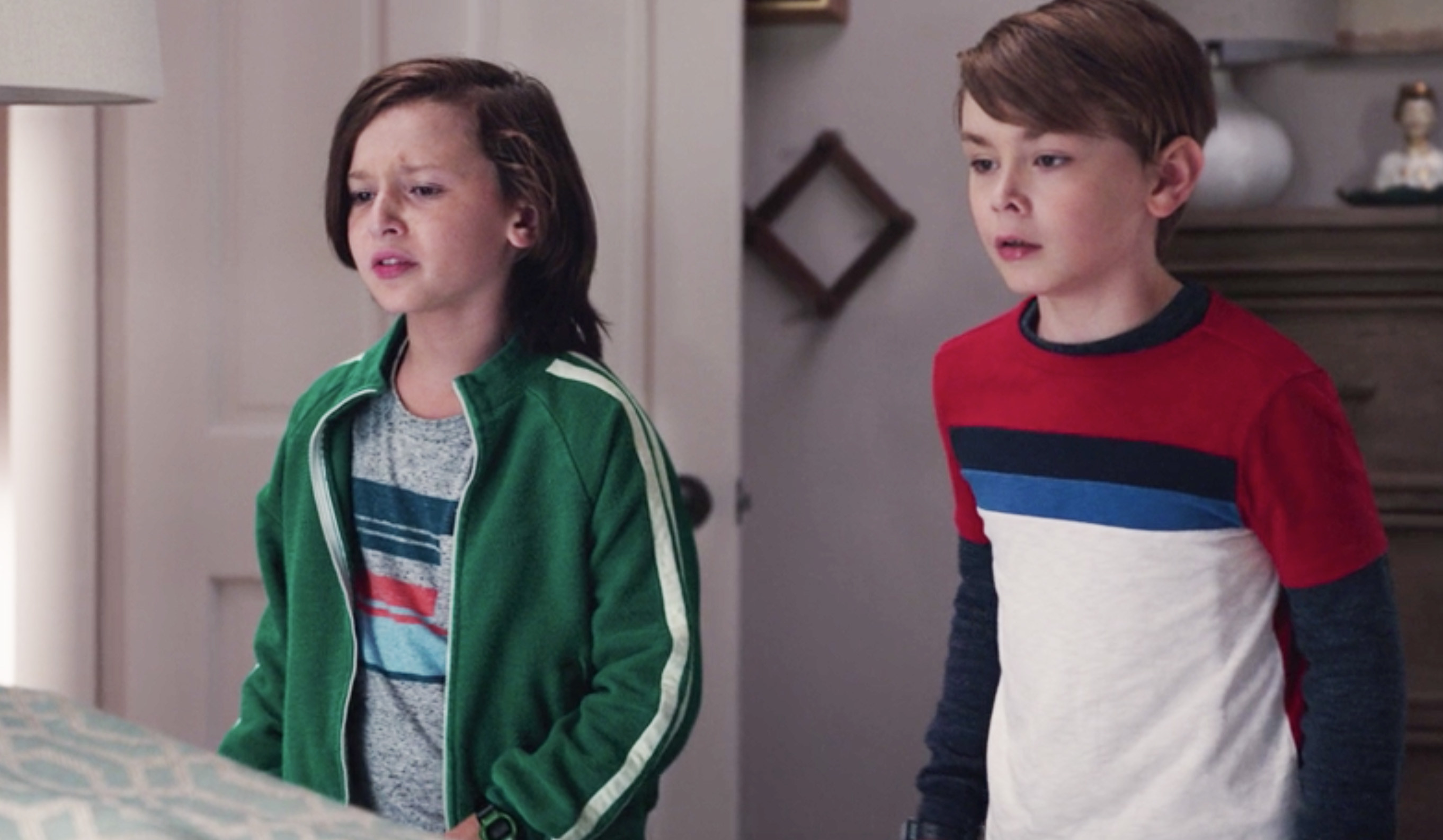 Tommy wearing a green jacket with a white stripe and Billy wearing a red, black, blue, and white striped shirt