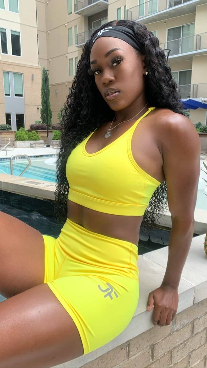 model wears bright yellow v-shaped sports bra with matching bike shorts