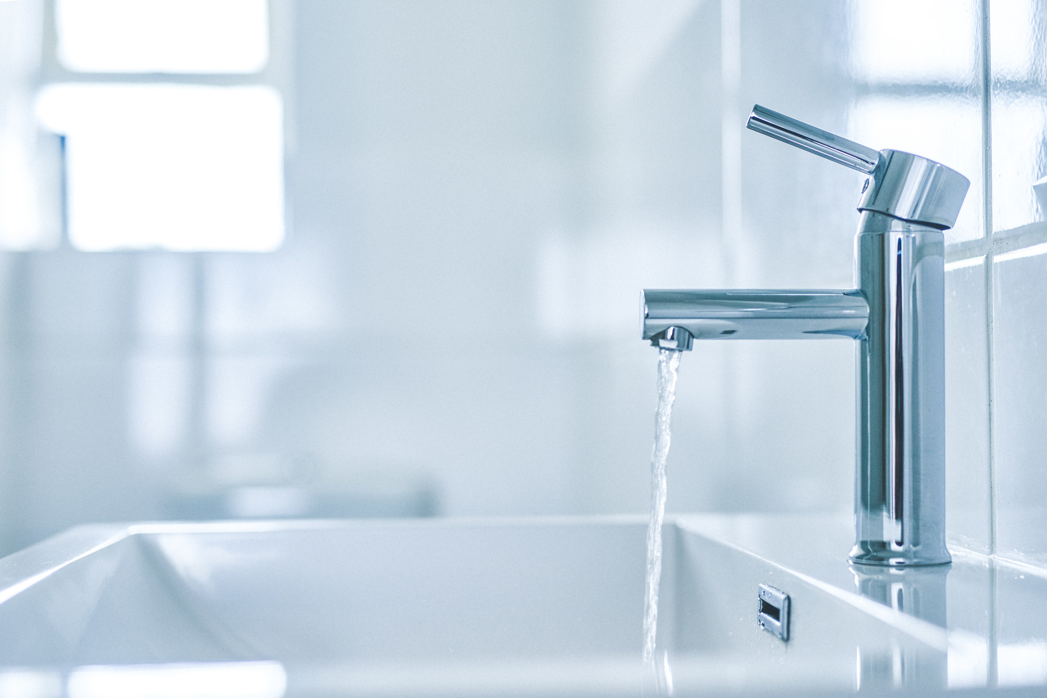 Shot of an open tap with running water in a bathroom at home.