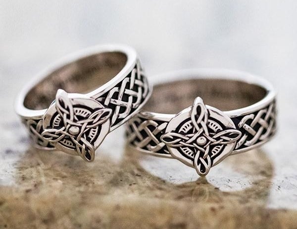 A pair of matching silver rings with an intricate Celctic design on the band and center with interior engraving 
