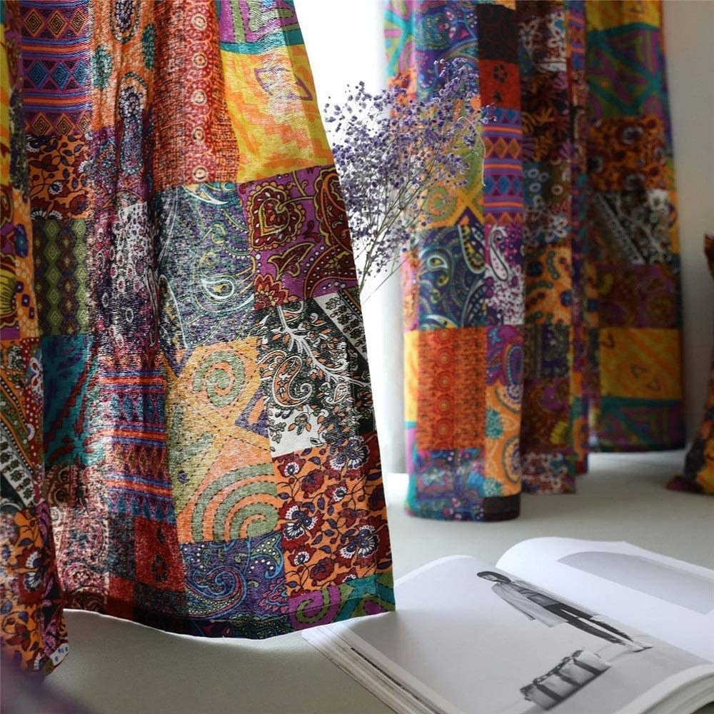 Long curtains with pieced-together squares with different fabrics in several different patterns and colors