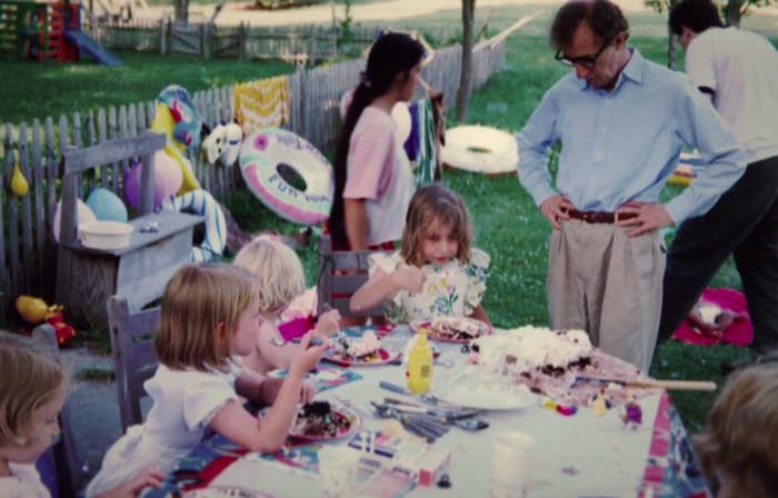 Allen stands over Dylan as she eats cake surrounding by other kids at an outdoor party in an image from the documentary