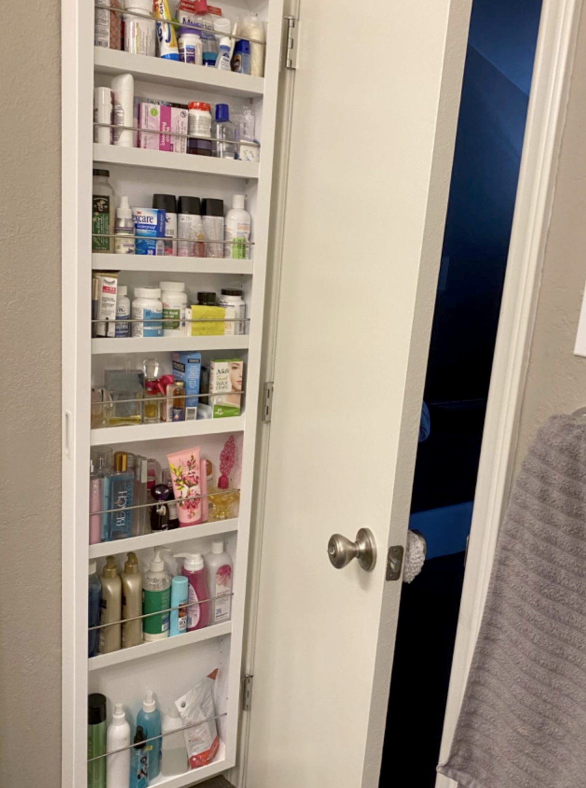 reviewer image of cabinet attached to bathroom door filled with medicine 