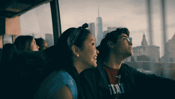 Peter and Lara Jean are looking out the bus window at New York City. 